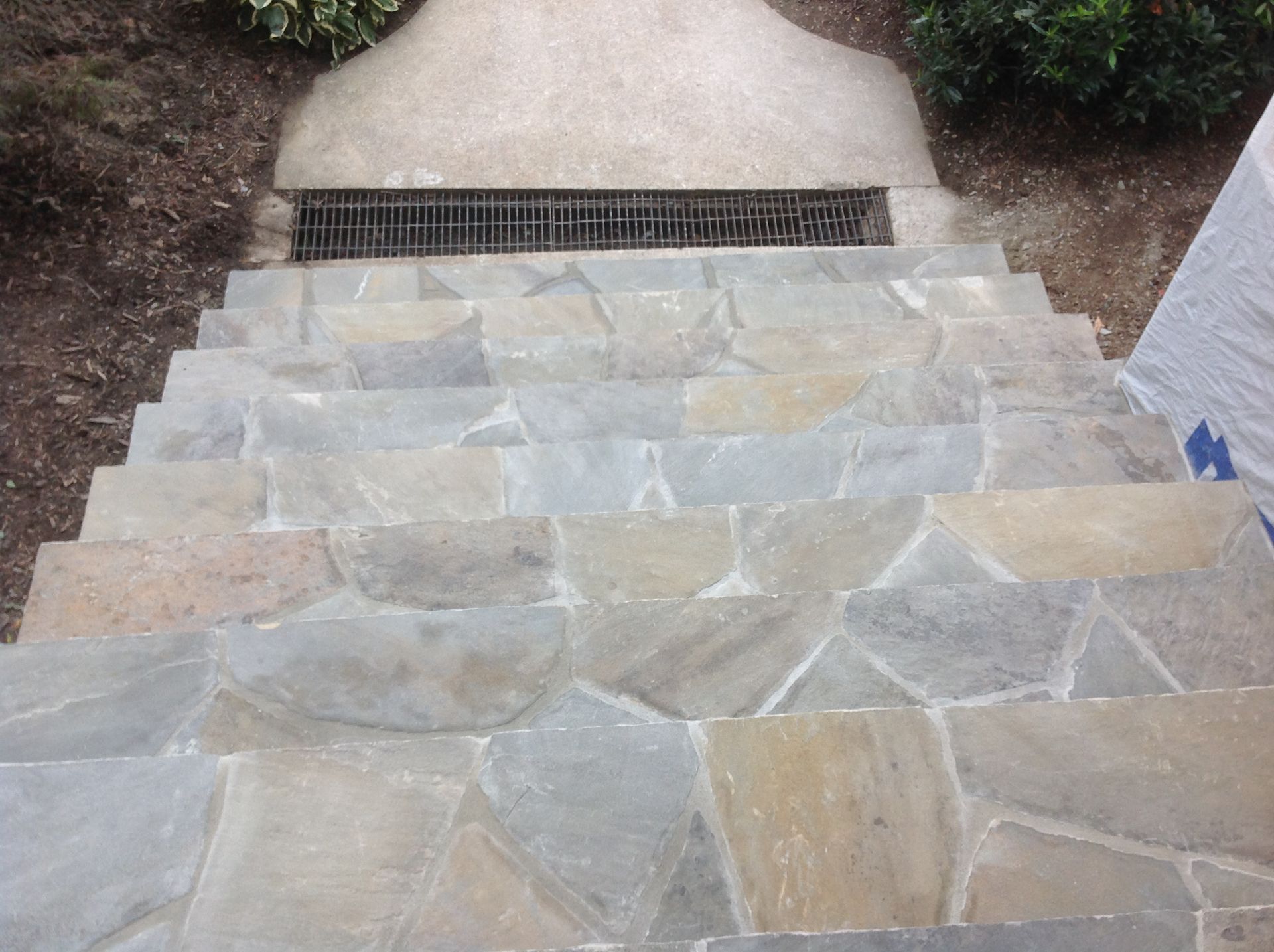 A set of stone stairs with a drain on the bottom