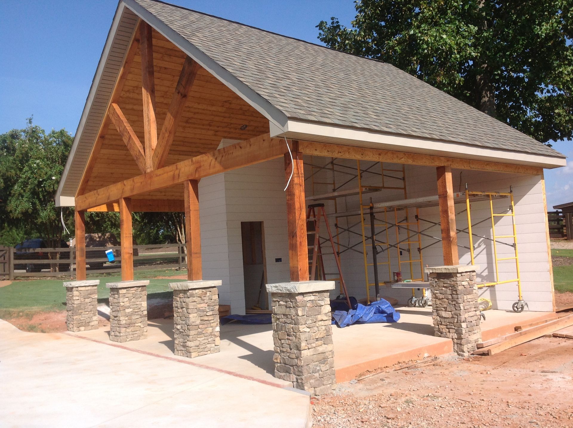 A building under construction with a wooden roof and stone pillars