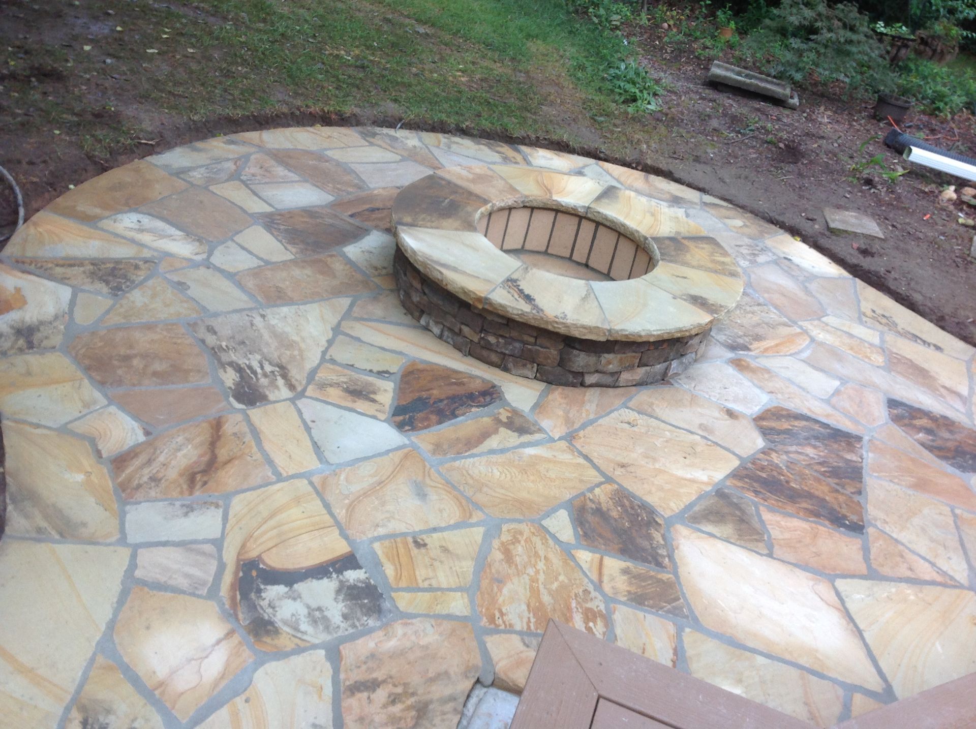A fire pit is sitting on top of a stone patio.