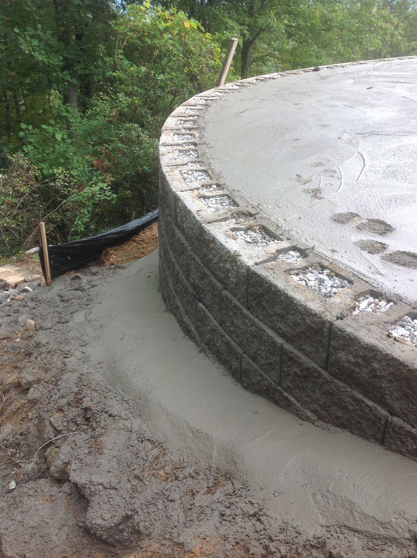 A concrete wall is being built around a pool.