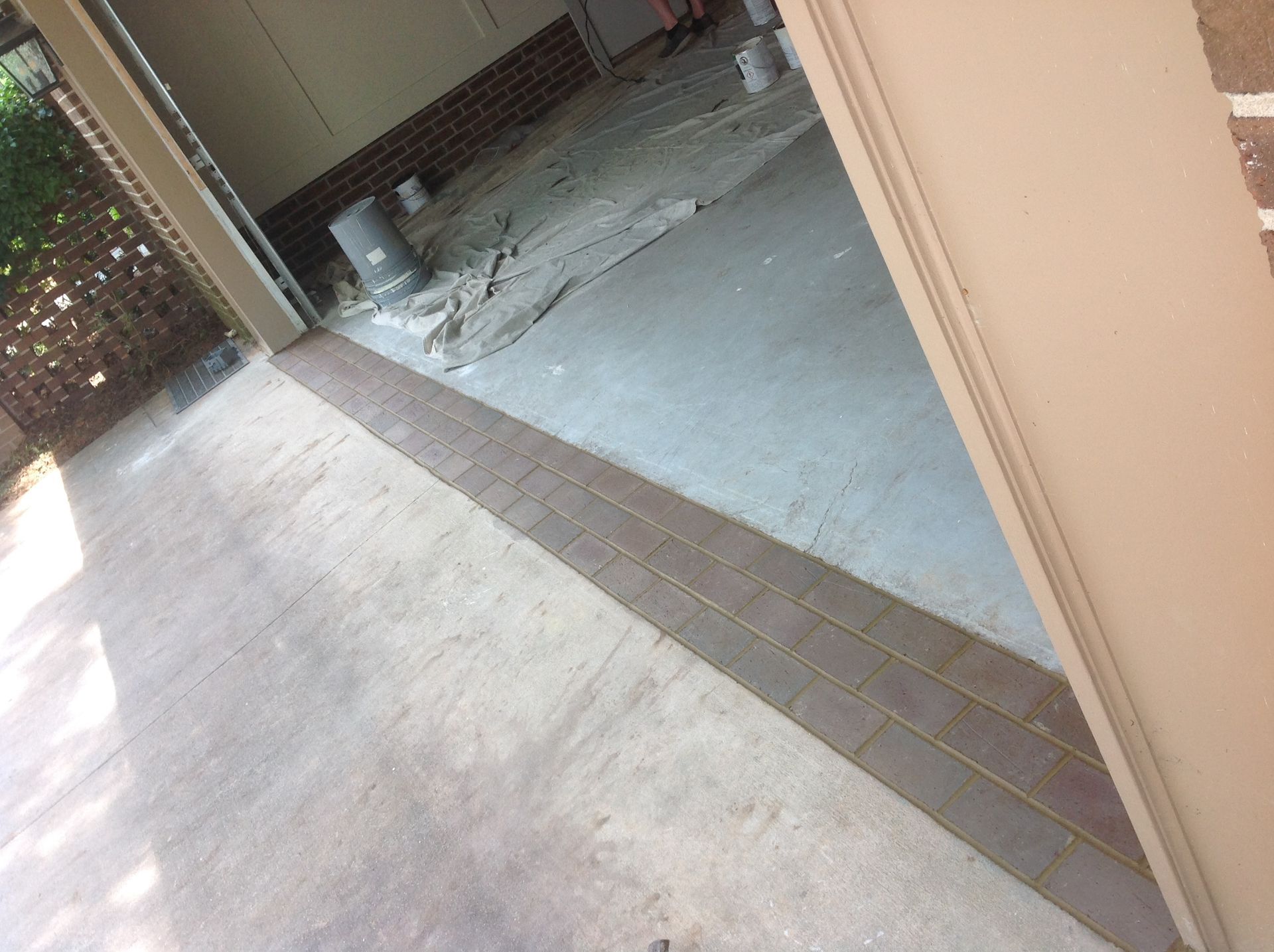 A garage with a brick border is being painted.