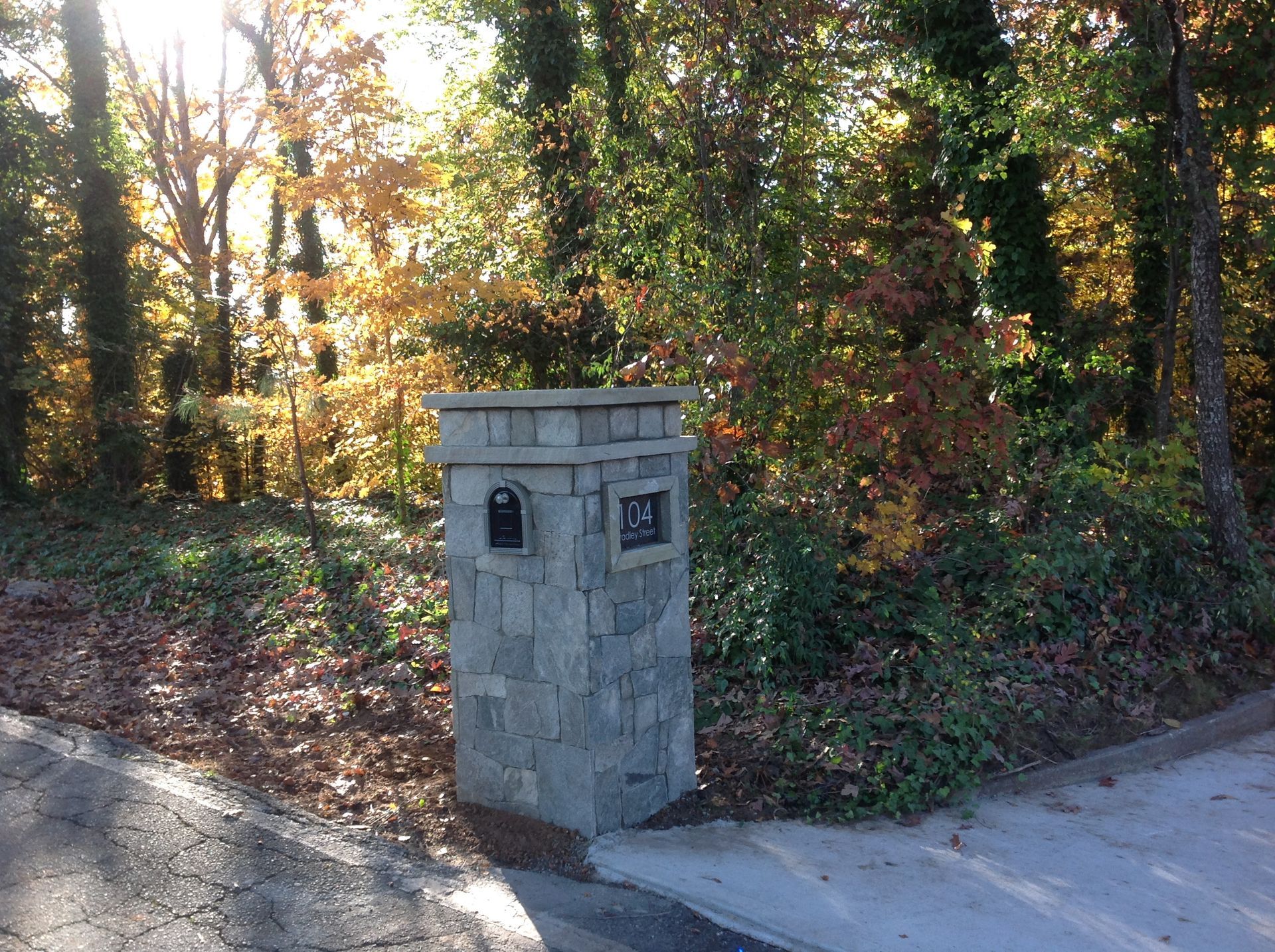 A stone pillar with a mailbox on it.