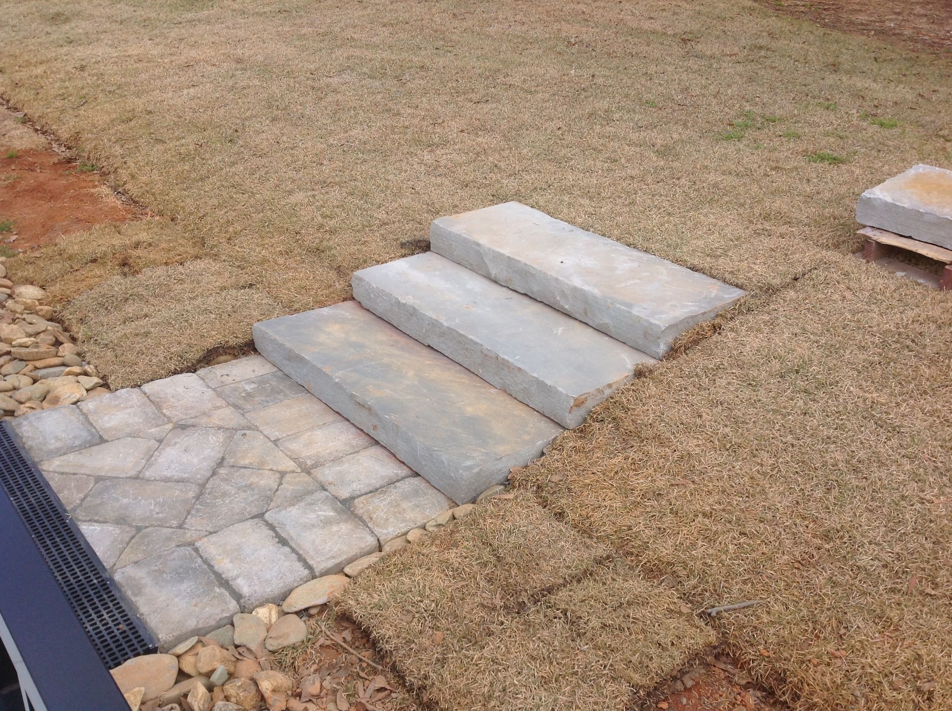 A set of concrete steps leading up to a grassy area.