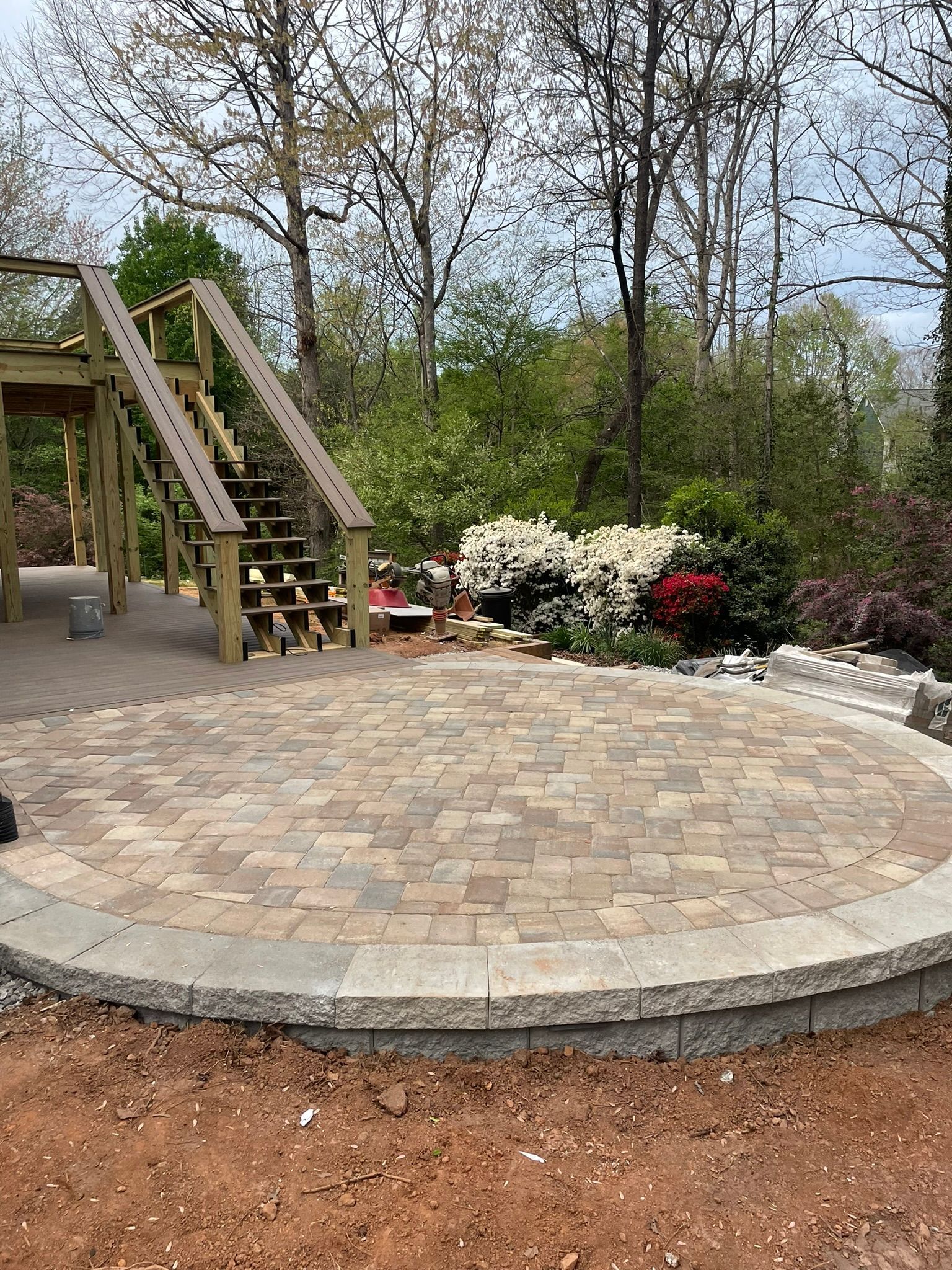 A circular patio with stairs leading up to it in a park.