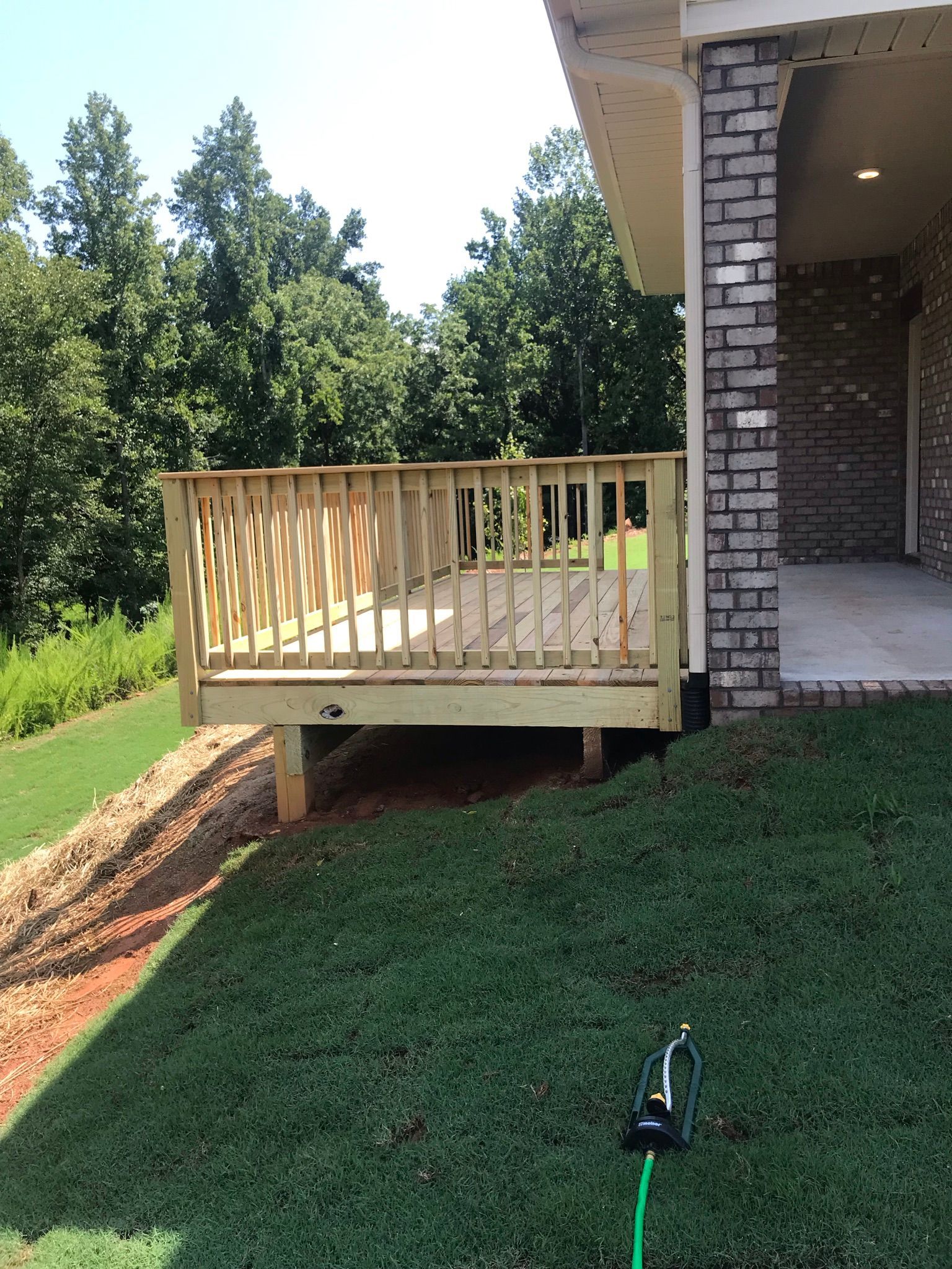 A brick house with a wooden deck in front of it