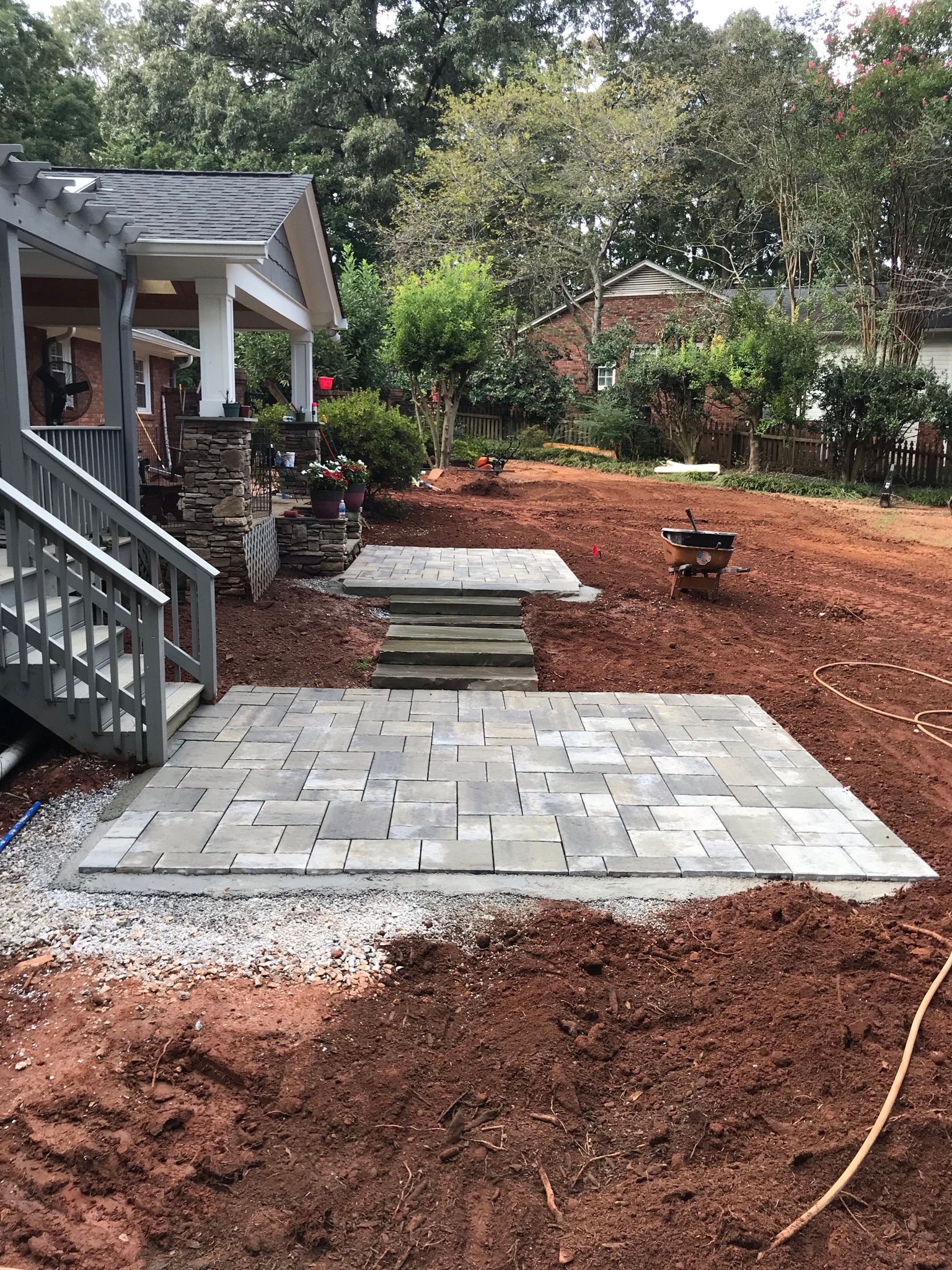 A patio is being built in the backyard of a house.