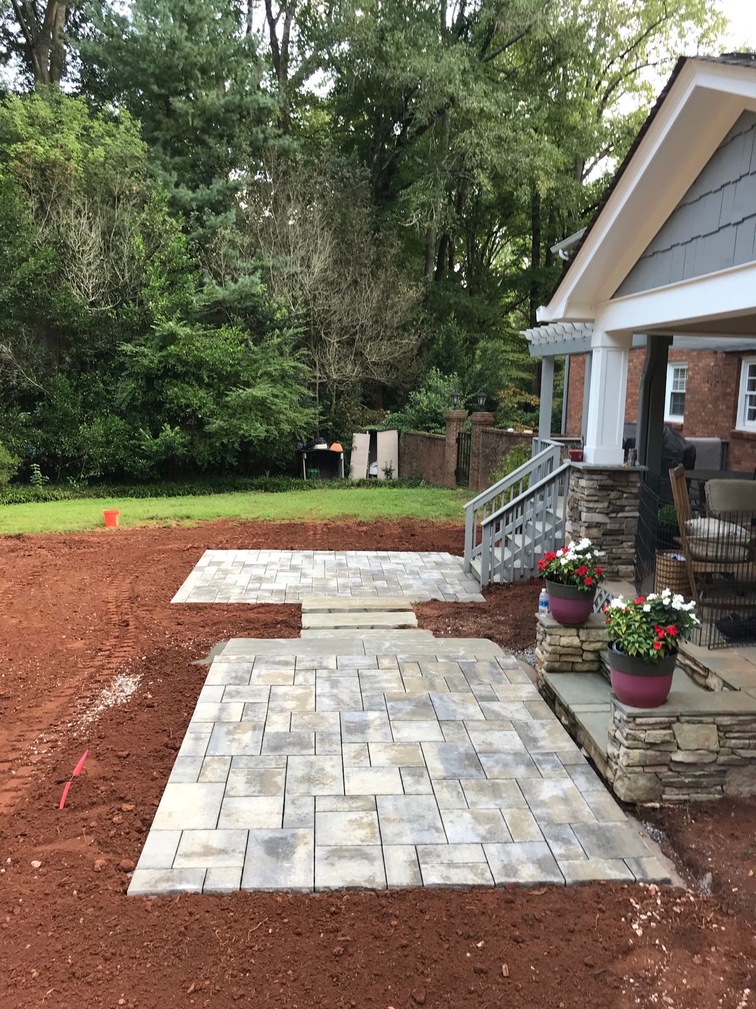 A brick walkway is being built in front of a house.