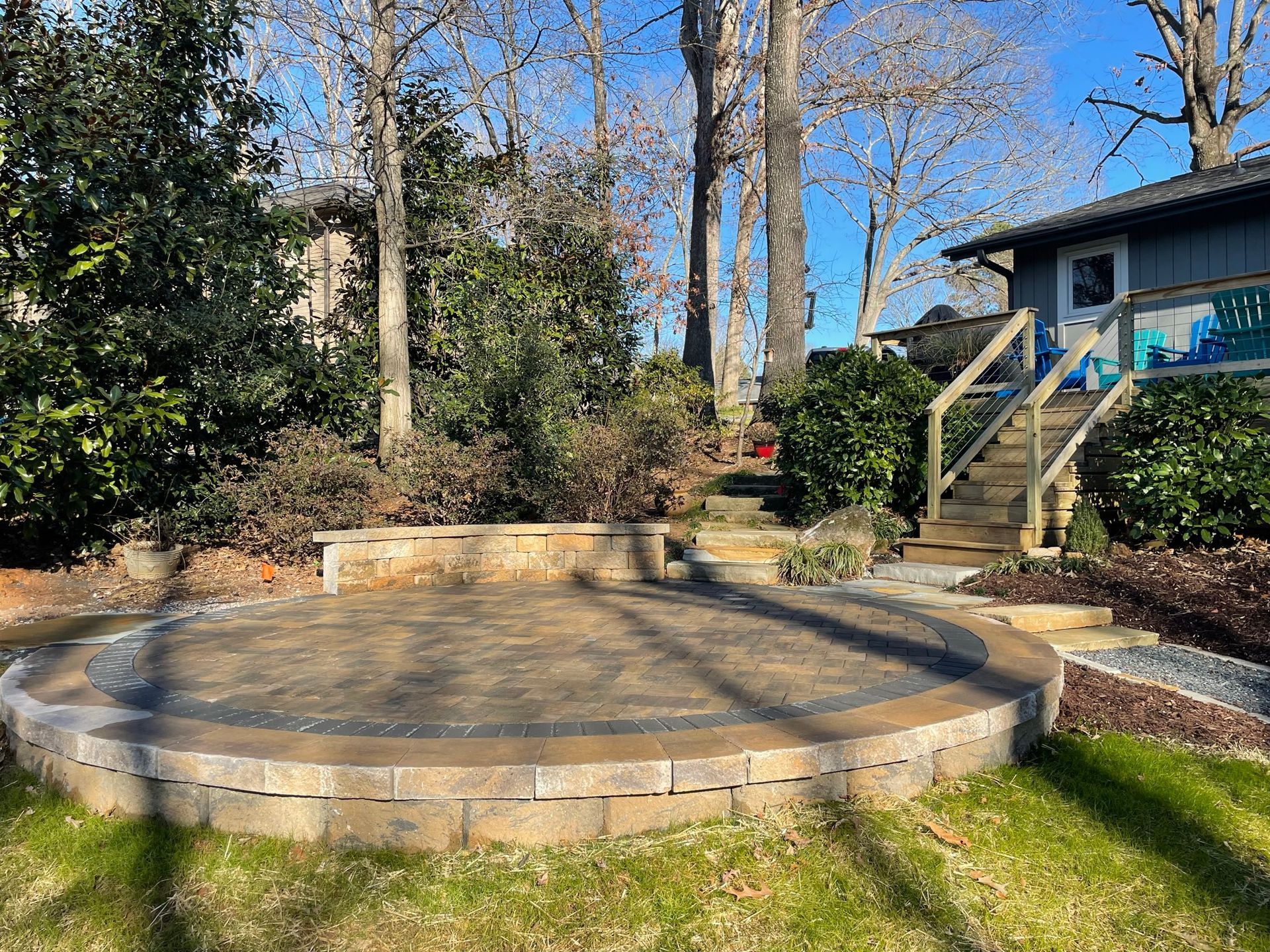 A circular patio with stairs leading to a house in the backyard.