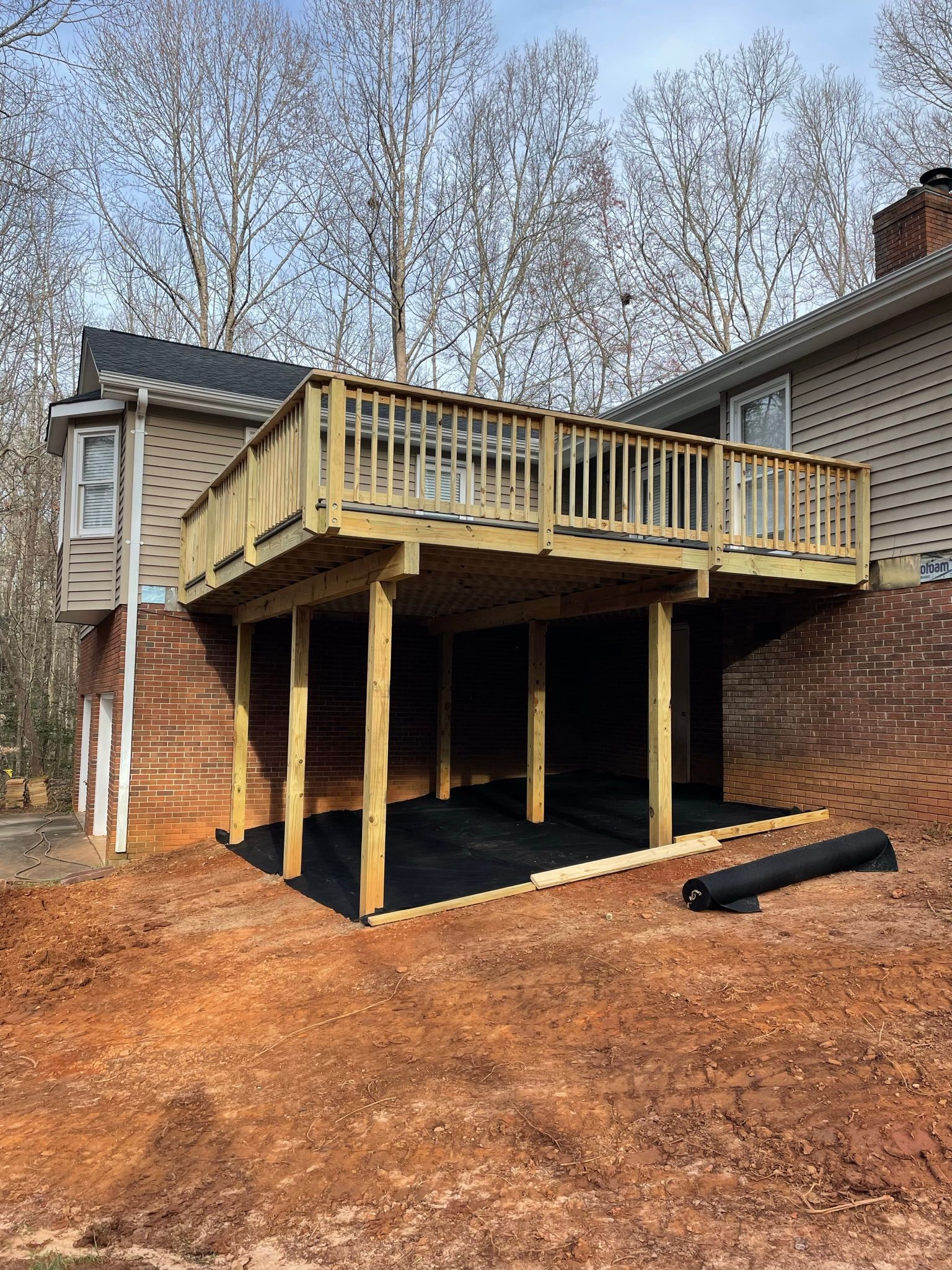 A wooden deck is being built underneath a house.