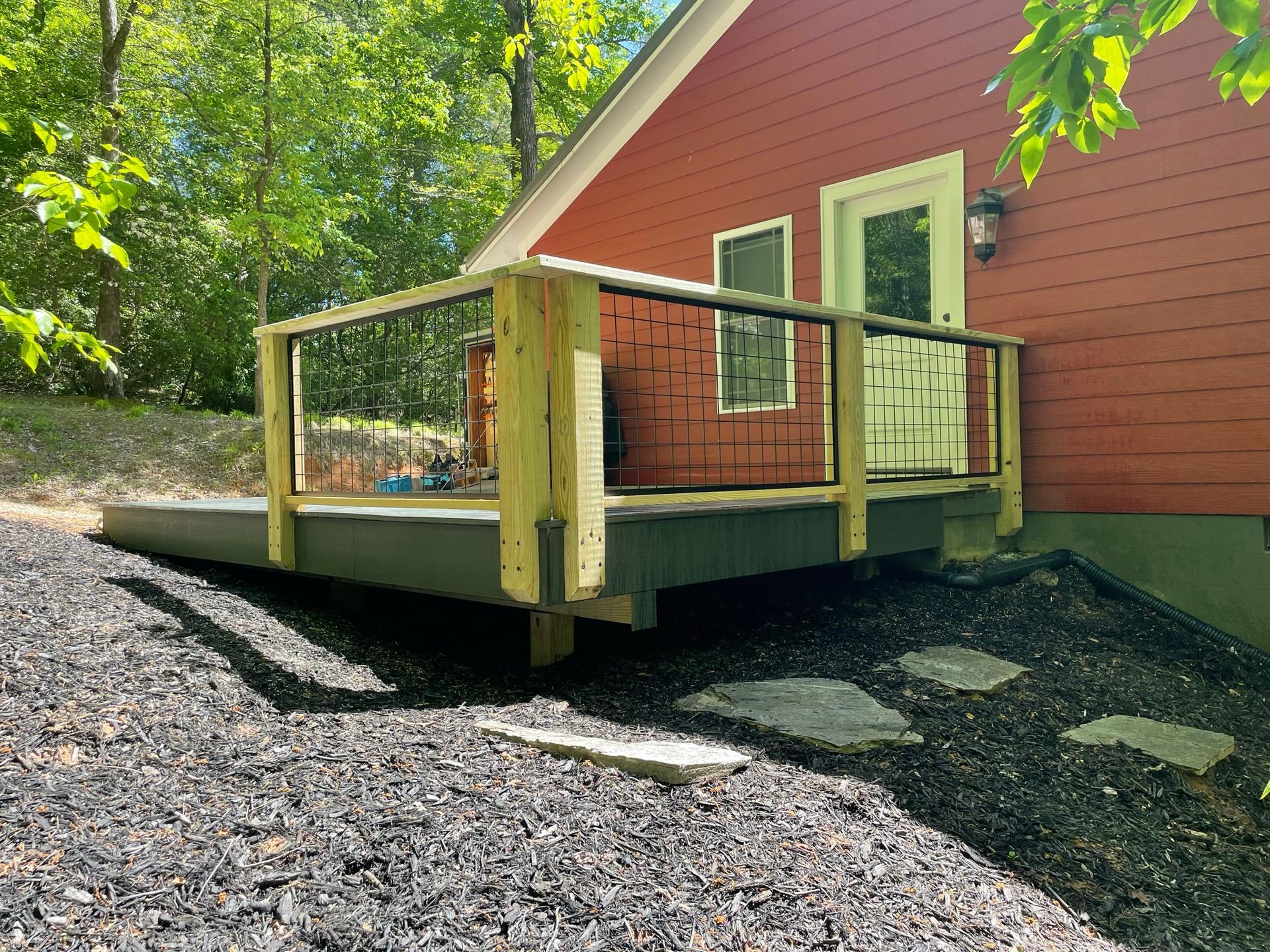 A red house with a wooden deck in front of it.