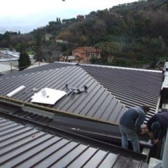 Due uomini stanno lavorando sul tetto di un edificio