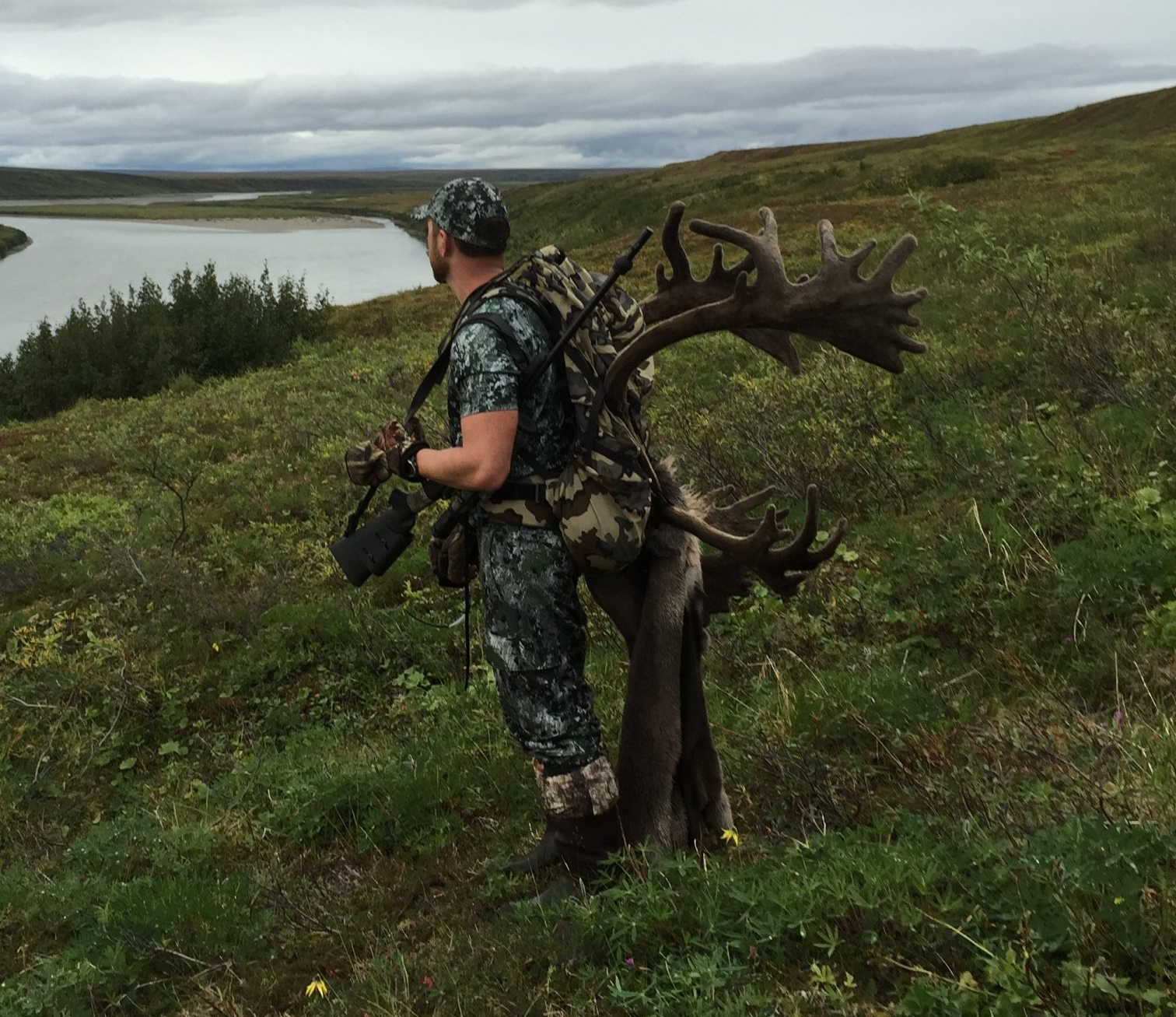 A man carrying a large deer in a field