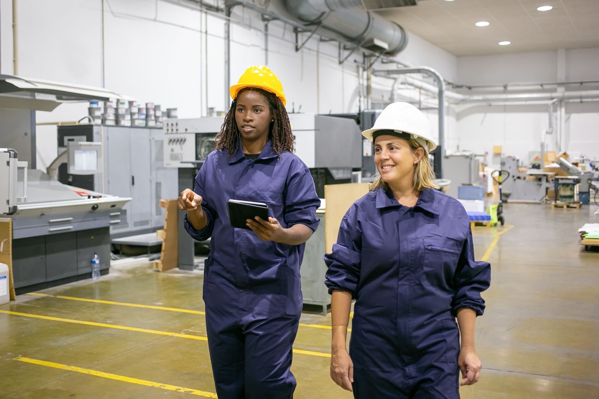 A woman wearing a hard hat and a face mask.