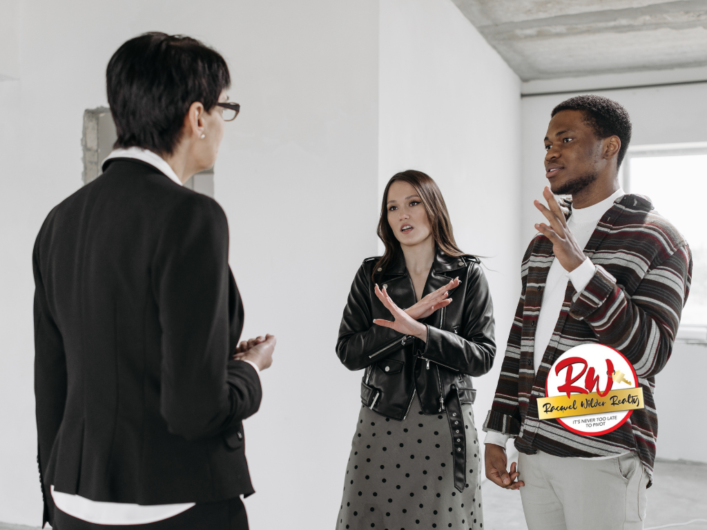 Real estate agent speaking to a couple, couple appears unhappy in a white room.