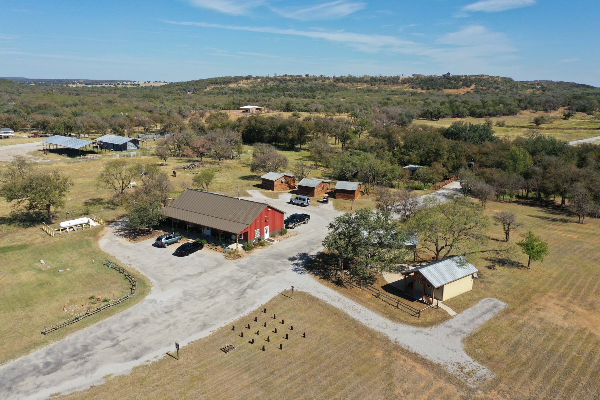 An aerial view of a farm with a red barn in the middle of a field.