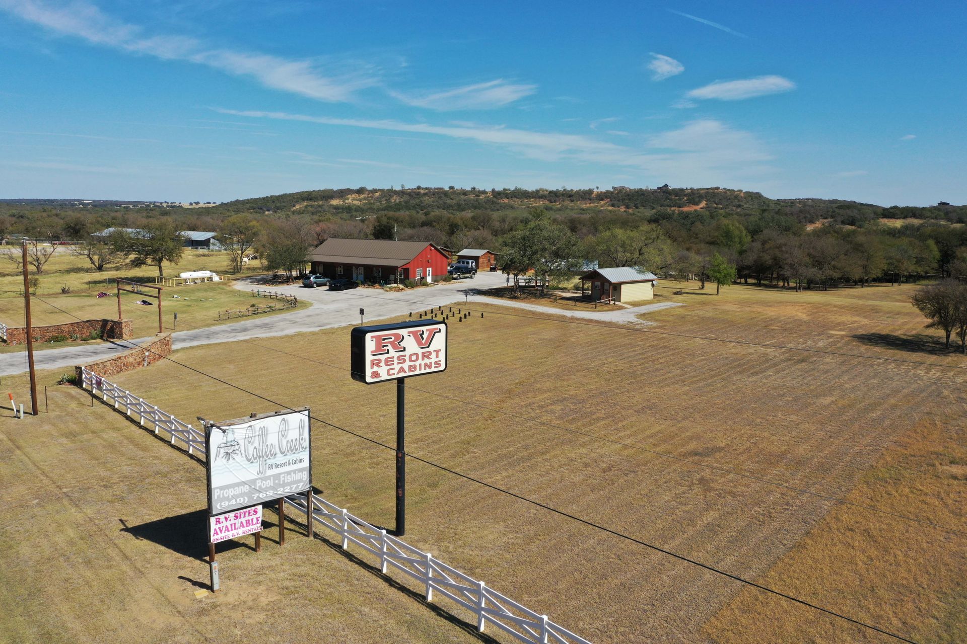 An aerial view of a for sale sign in a field