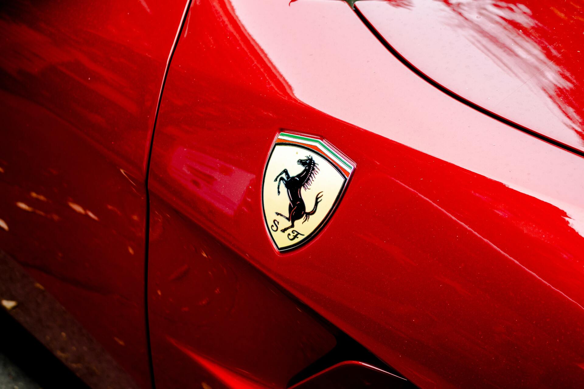 Close-up of a red Ferrari car badge on the side panel