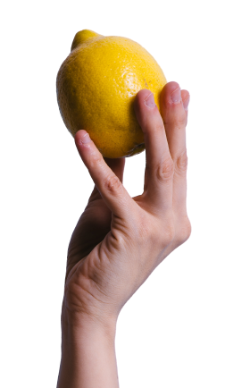 A woman 's hand is holding a lemon between two fingers