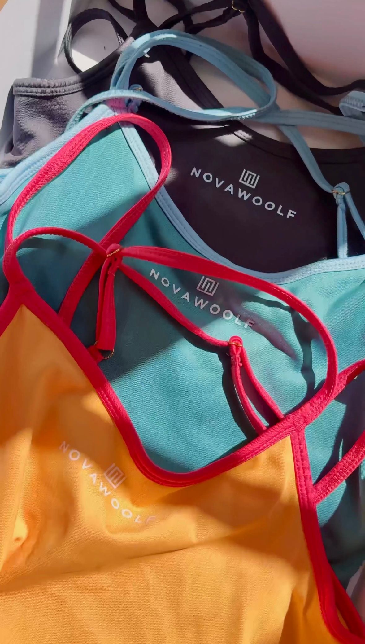 Close-up of colorful Nova Woof clothing items, including tops with red, blue, and yellow accents.