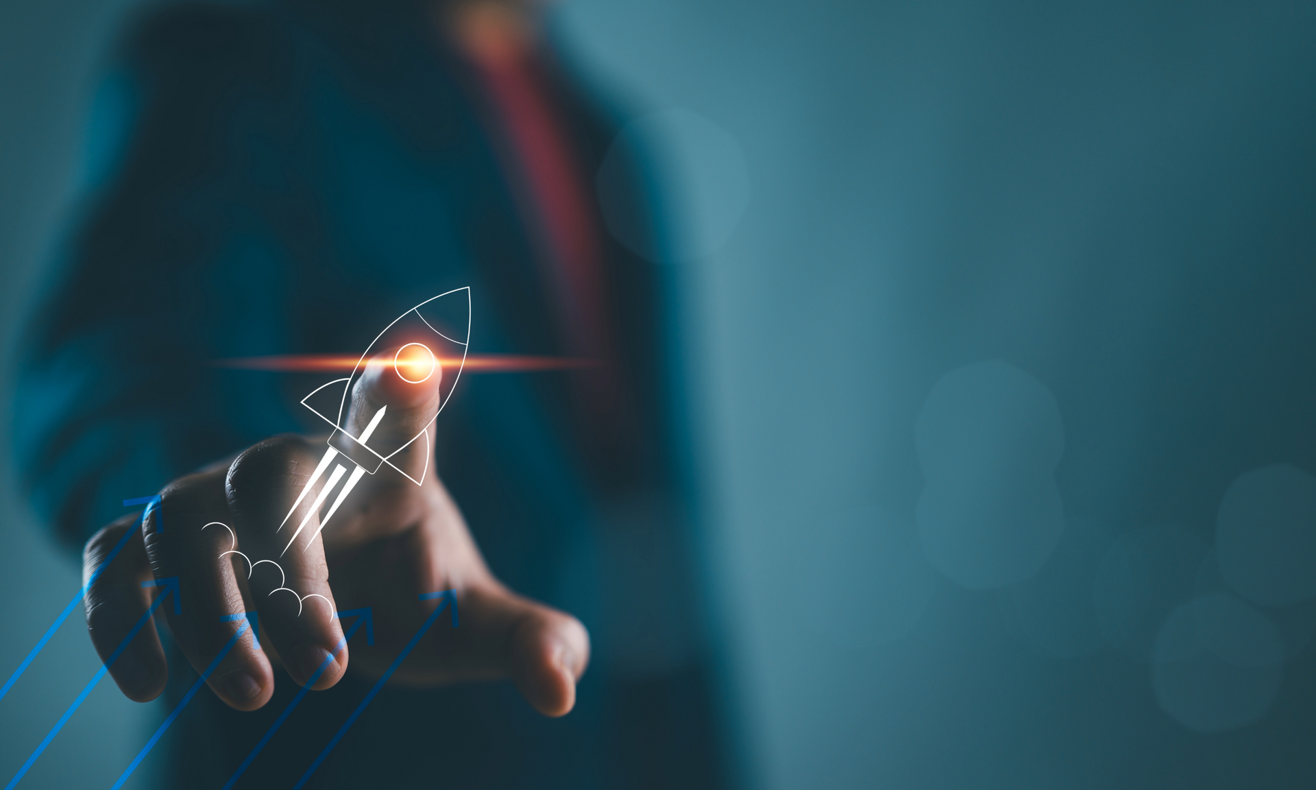 Ein Geschäftsmann in Anzug zeigt mit dem Finger auf ein digitales Symbol einer startenden Rakete, das von futuristischen Licht- und Pfeileffekten umgeben ist, auf dunklem Hintergrund.