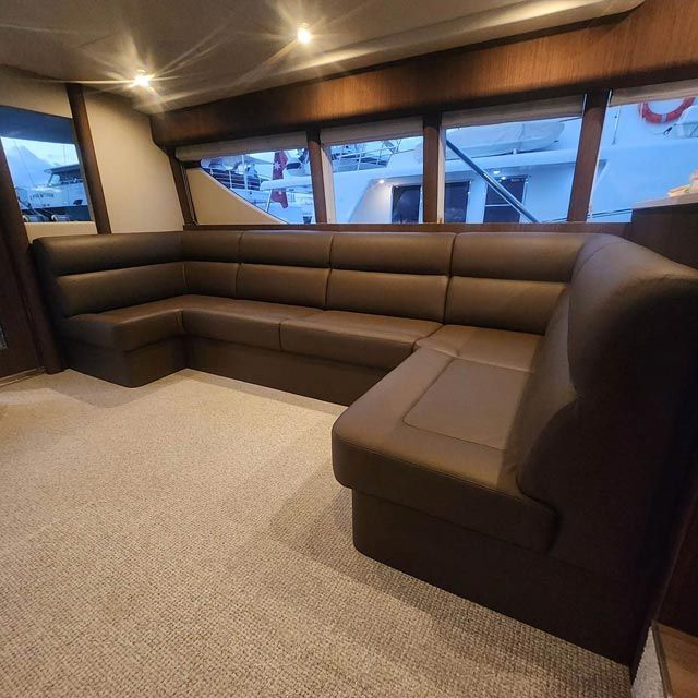 A Couch in a Living Room With a Boat in the Background — Coastal Coverings In Smithfield, QLD
