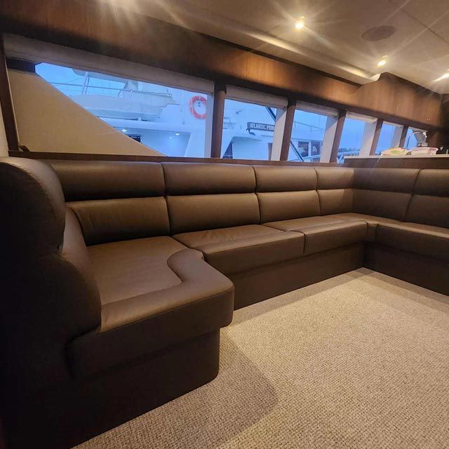 A Couch in a Room With a Boat in the Background — Coastal Coverings In Smithfield, QLD