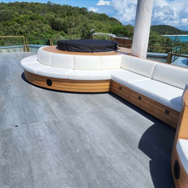 A Round Couch on a Patio With a Hot Tub in the Middle — Coastal Coverings In Smithfield, QLD