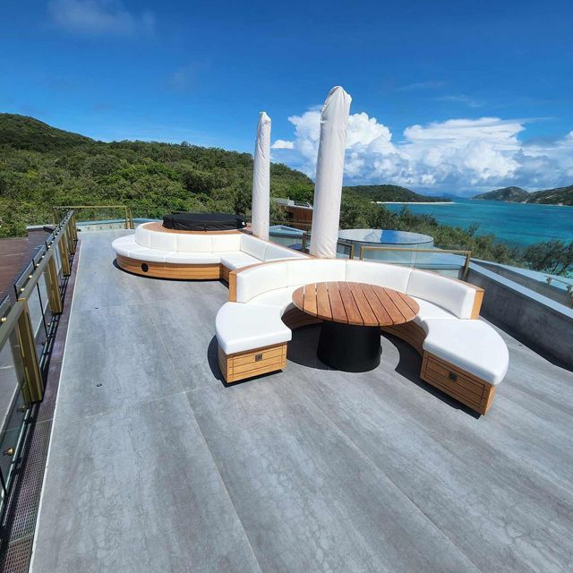 A Rooftop With a Couch and a Table Overlooking the Ocean — Coastal Coverings In Smithfield, QLD