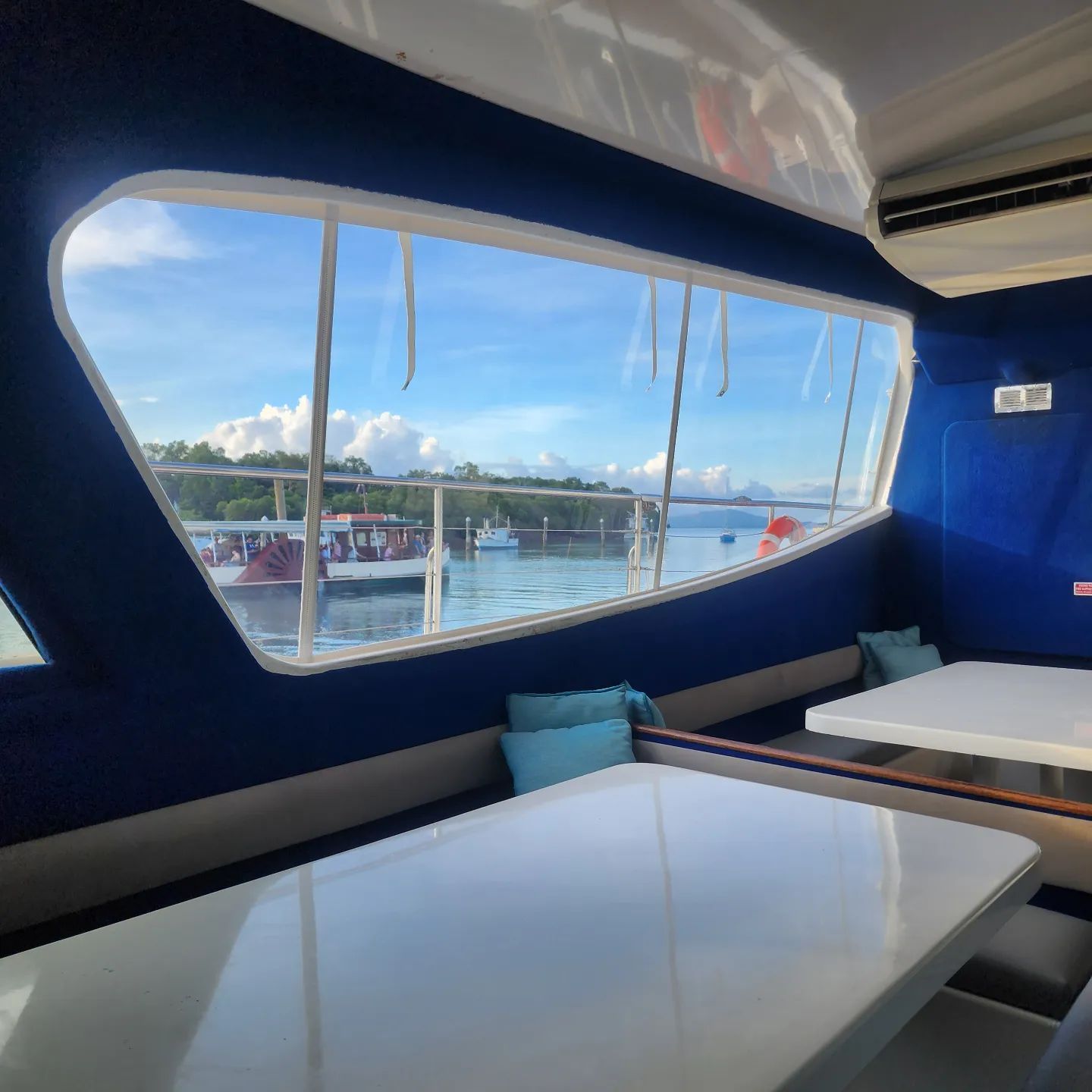 A Room With Two Tables and a Large Window Overlooking a Body of Water — Coastal Coverings In Mareeba, QLD