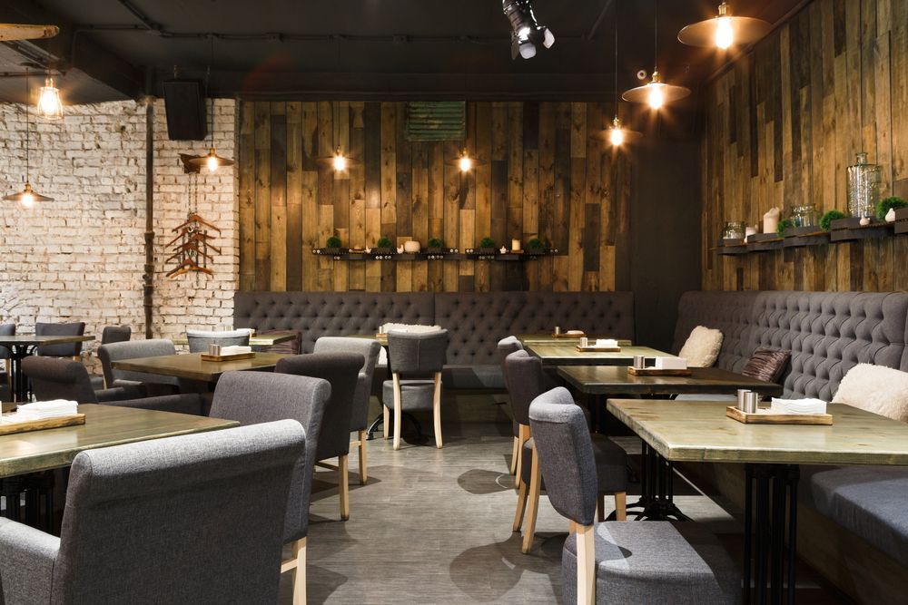 A Restaurant With Tables and Chairs and a Wooden Wall — Coastal Coverings In Port Douglas, QLD
