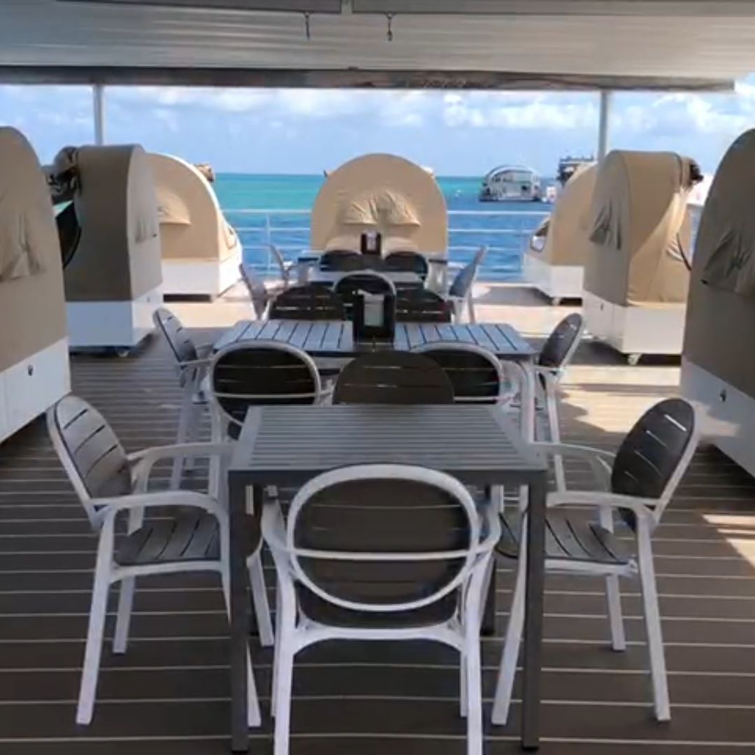 A Table and Chairs on a Deck Overlooking the Ocean — Coastal Coverings In Smithfield, QLD