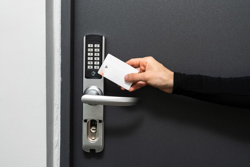 A person is inserting a credit card into a door lock.