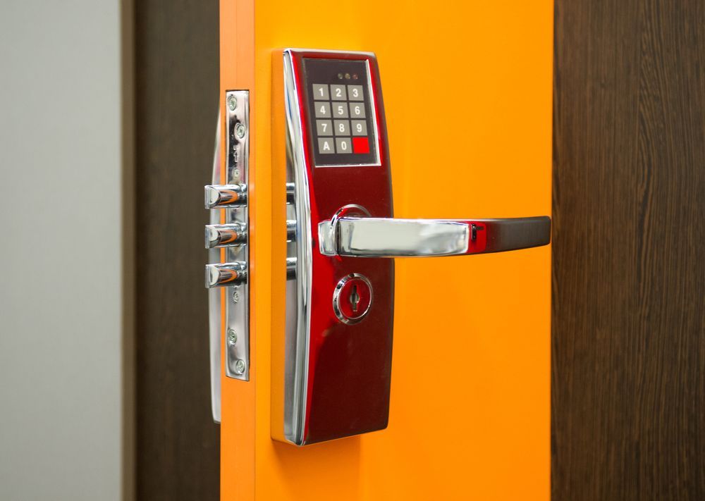 A close up of a digital door lock on an orange door.