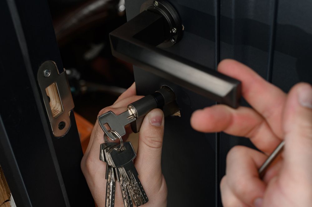 A person is holding a bunch of keys and a door handle.