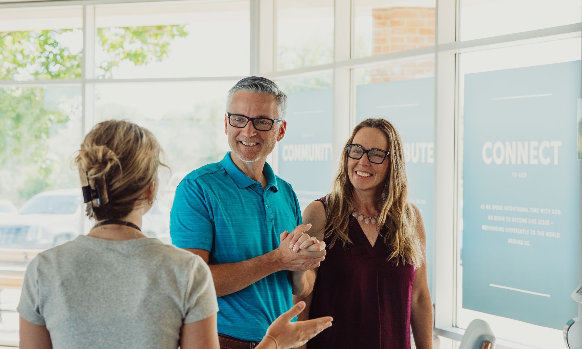 A man is holding a baby in a crowd of people.