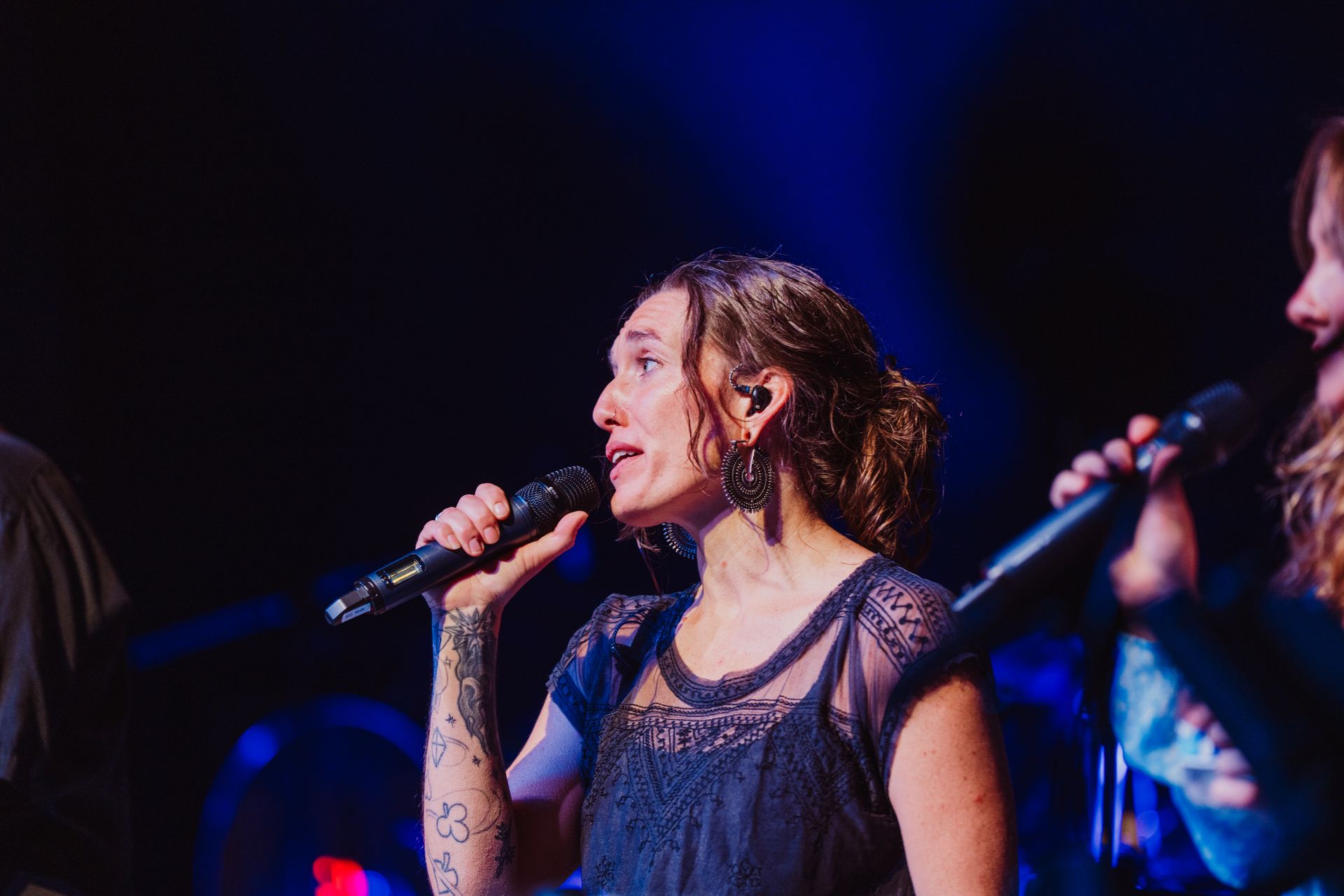 A man is playing an acoustic guitar on a stage.