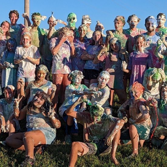 A group of people covered in paint are posing for a picture.