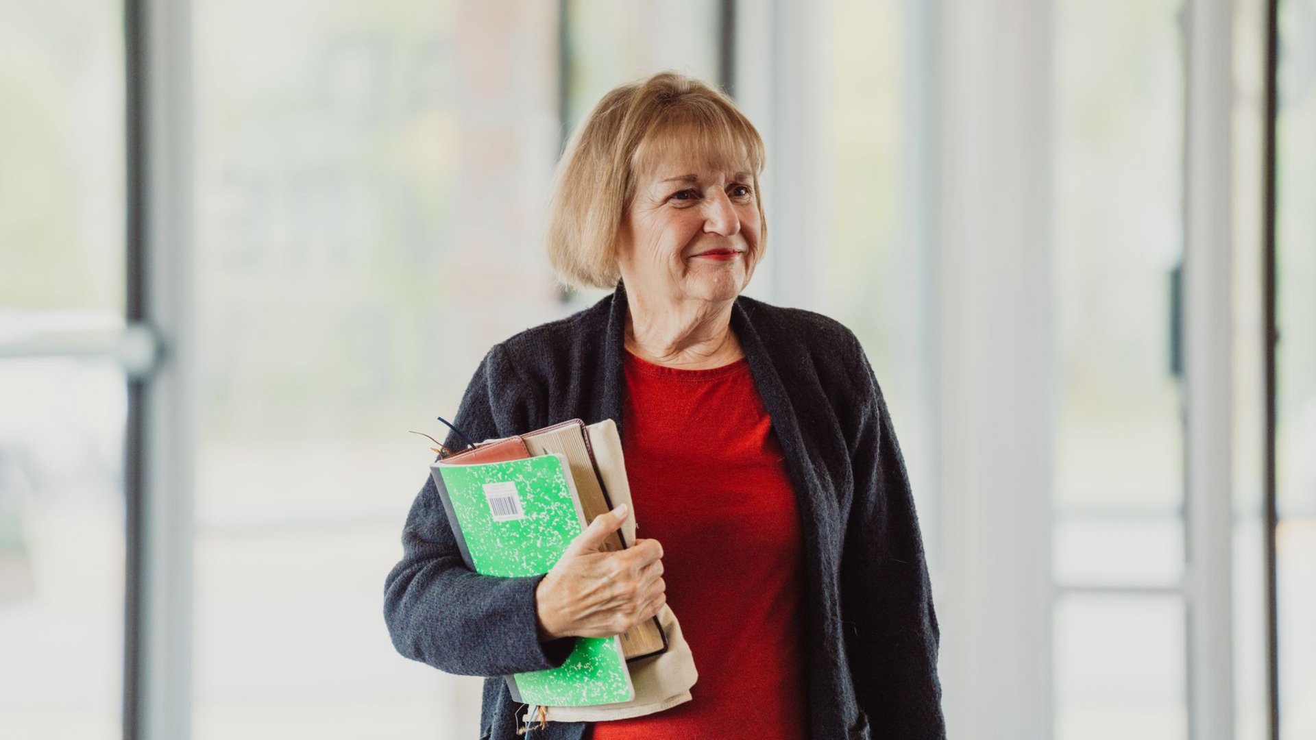 Two women are hugging each other in a hallway.