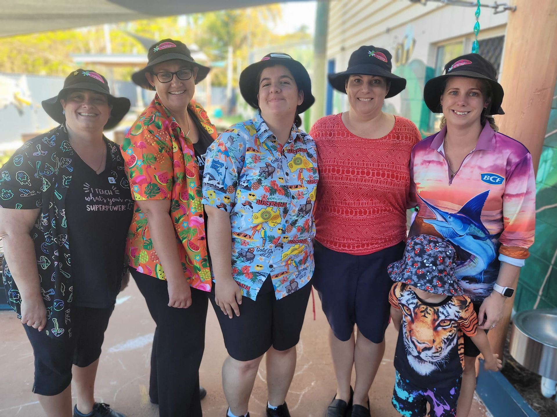 A group of women and a child are posing for a picture.