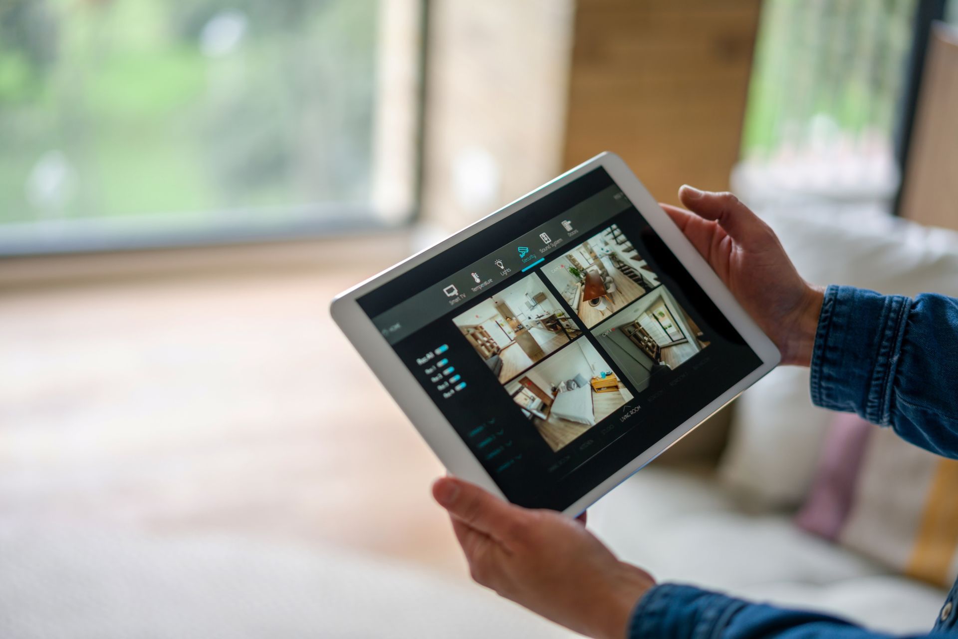 Person uses a smartphone and tablet to operate a security system by Honeywell. Devices show green and red icons with a store in the background.