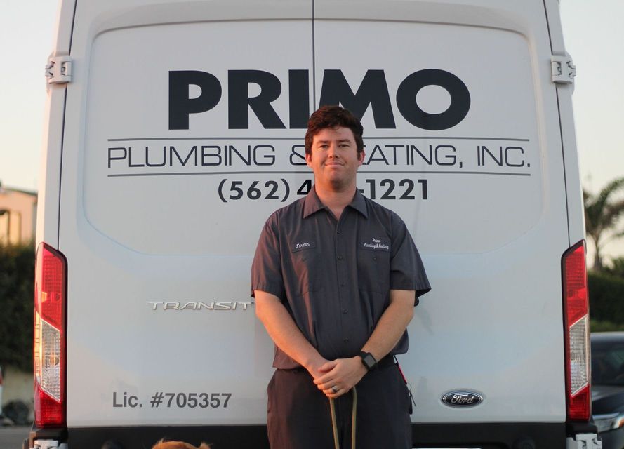 A man standing in front of a primo plumbing and heating van