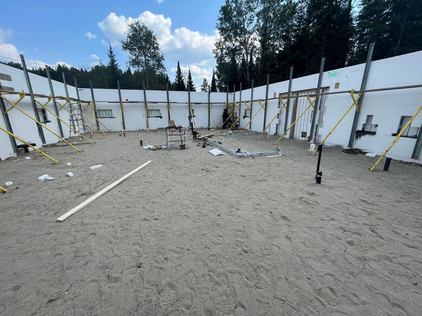 Un chantier avec beaucoup de murs blancs et d'échafaudages.