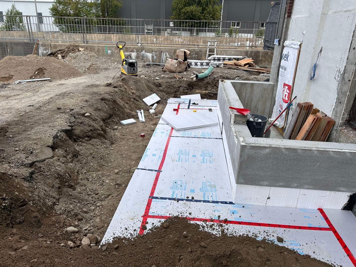 Un chantier avec beaucoup de terre et un mur en béton en construction.