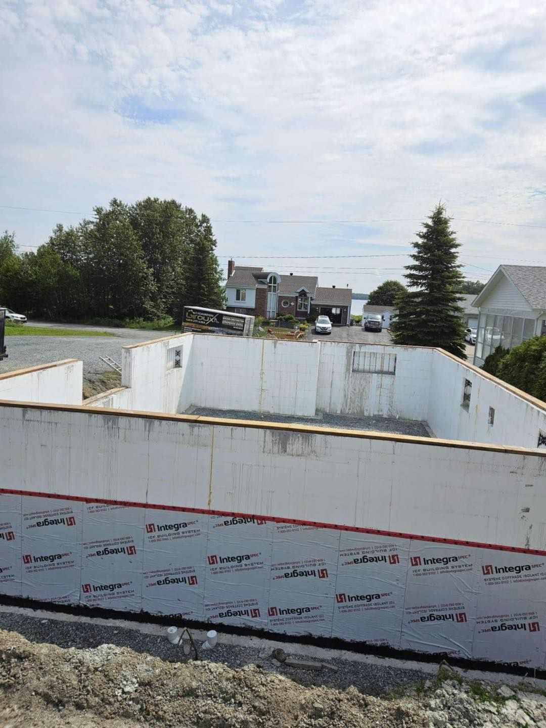 Un grand mur blanc est en cours de construction dans un quartier résidentiel.