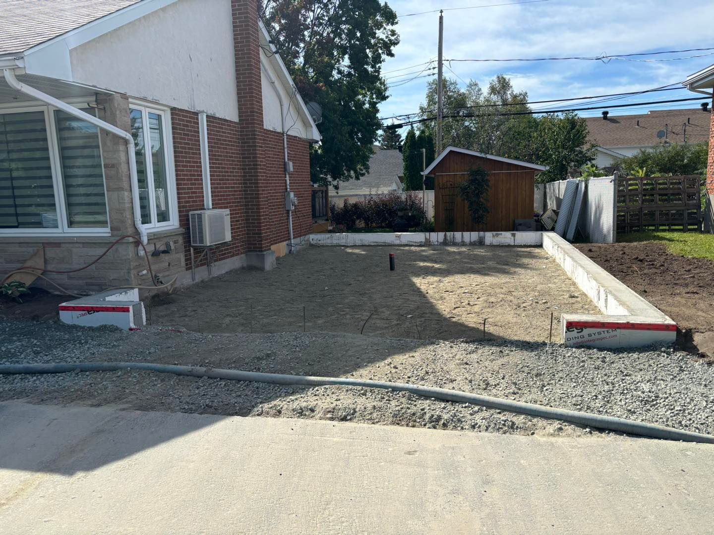 Une maison en briques avec une allée de gravier devant elle.