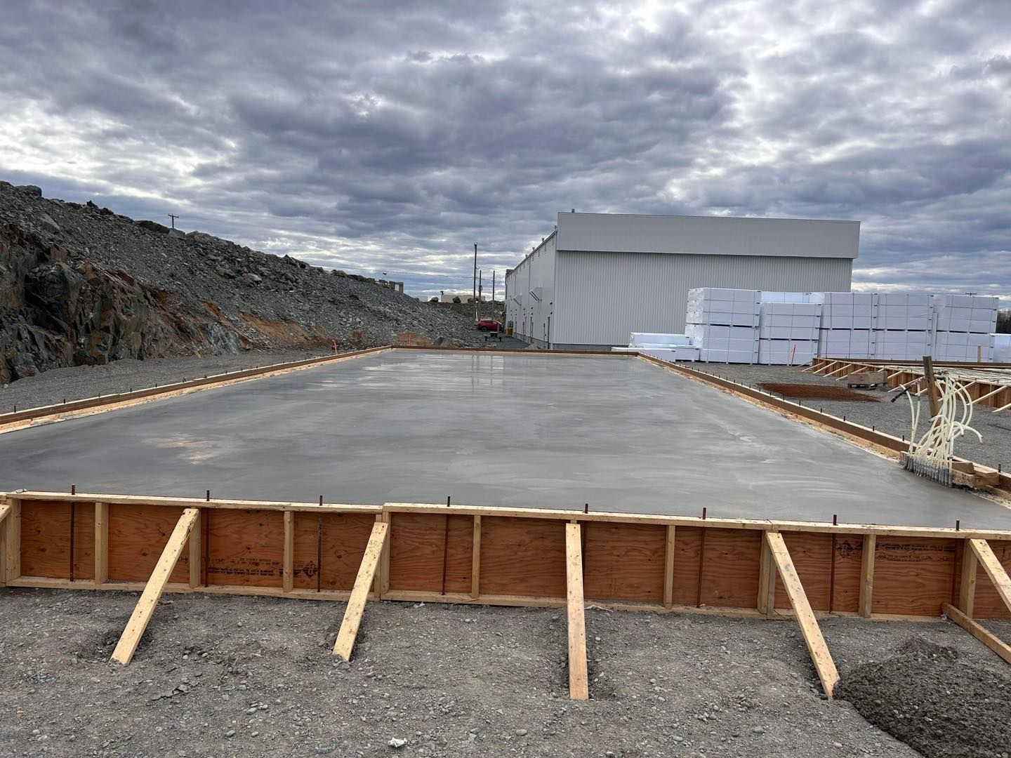 Un grand bâtiment est en construction à côté d'une grande dalle de béton.