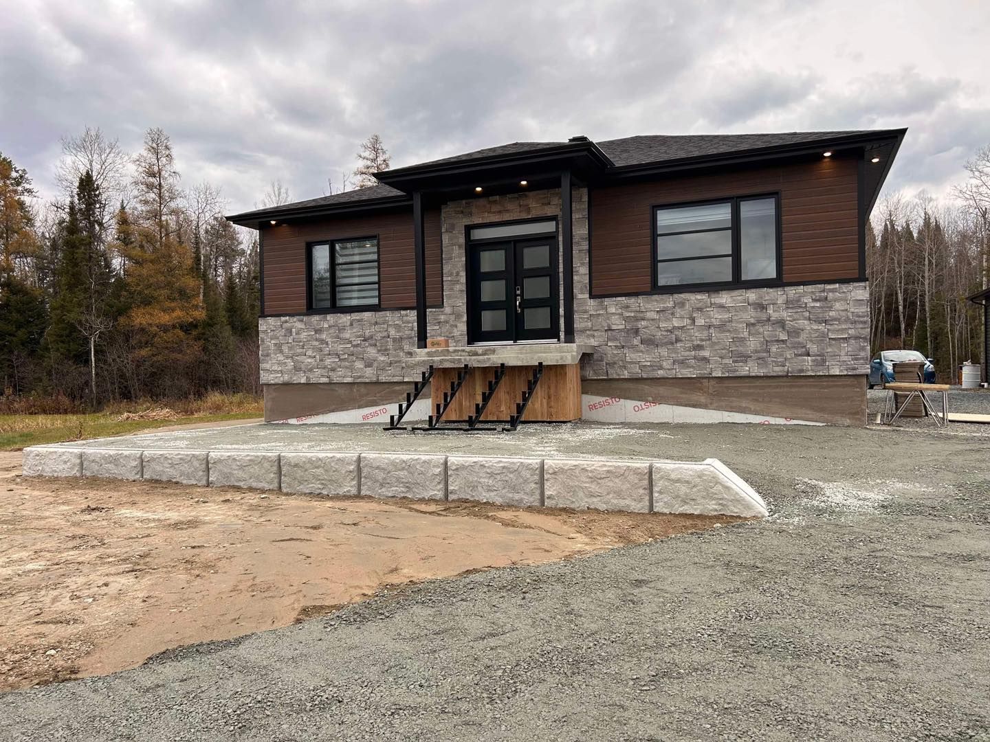 Une grande maison est située sur un terrain en gravier.