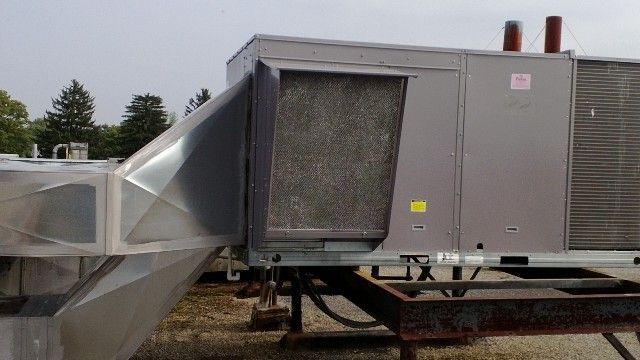 A large air conditioner is sitting on top of a trailer.
