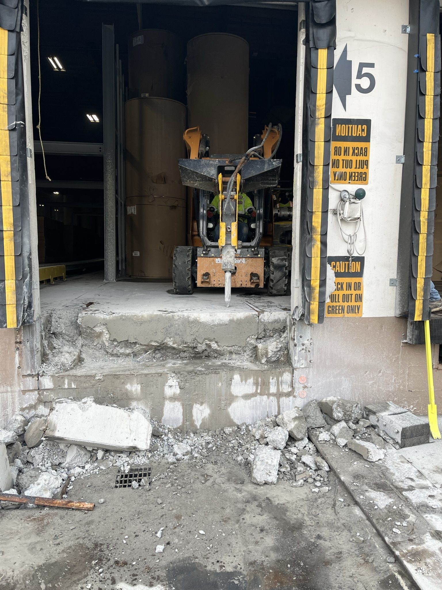 A forklift is sitting in the doorway of a warehouse.