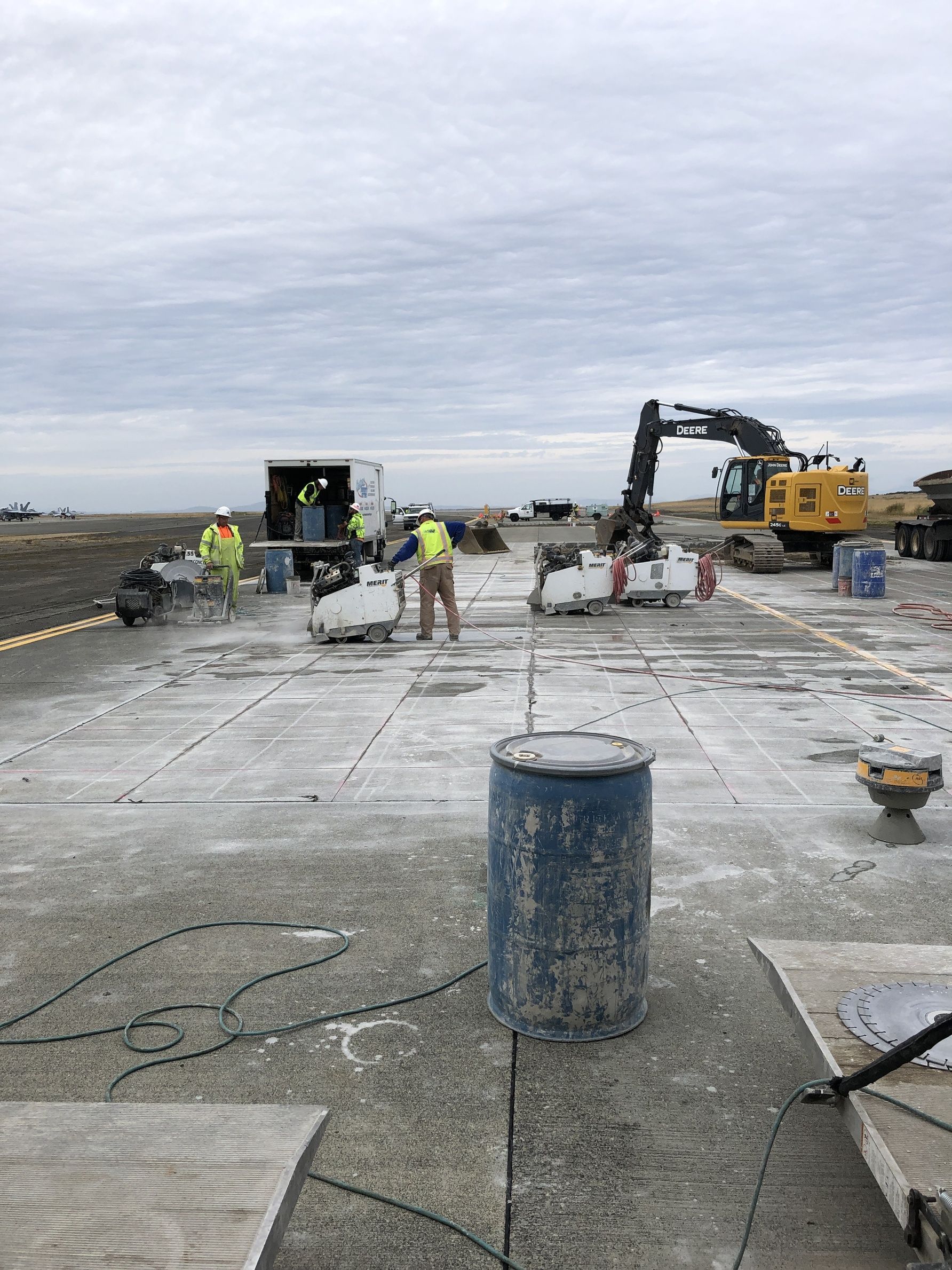A group of construction workers are working on a concrete floor.